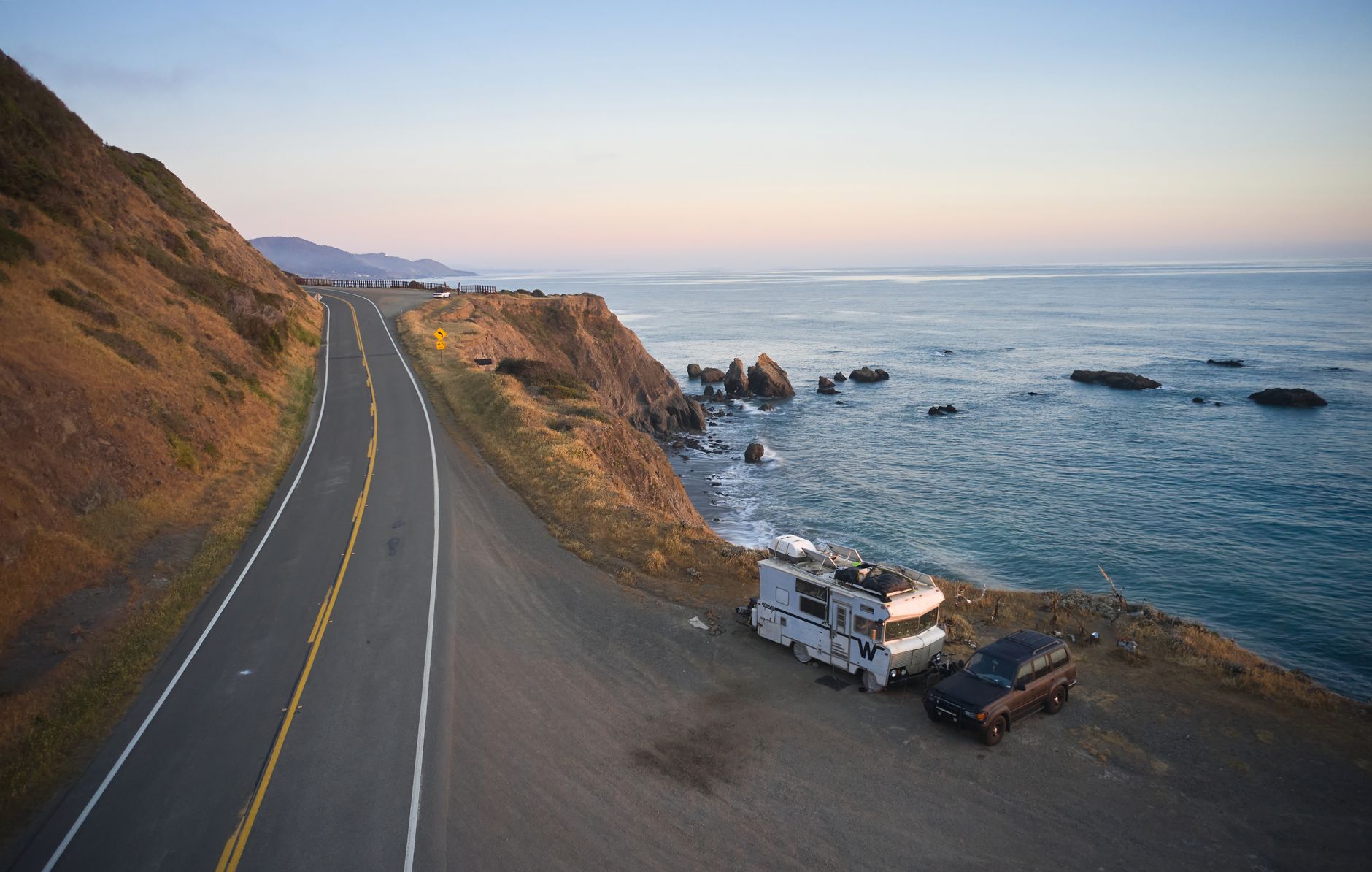 Campervan driving along New Zealand coastal cliff road